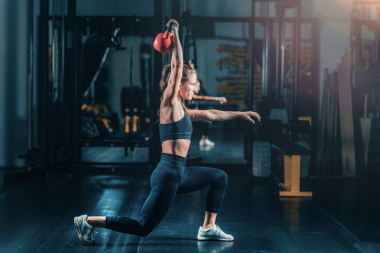 woman overhead lunge with kettlebell